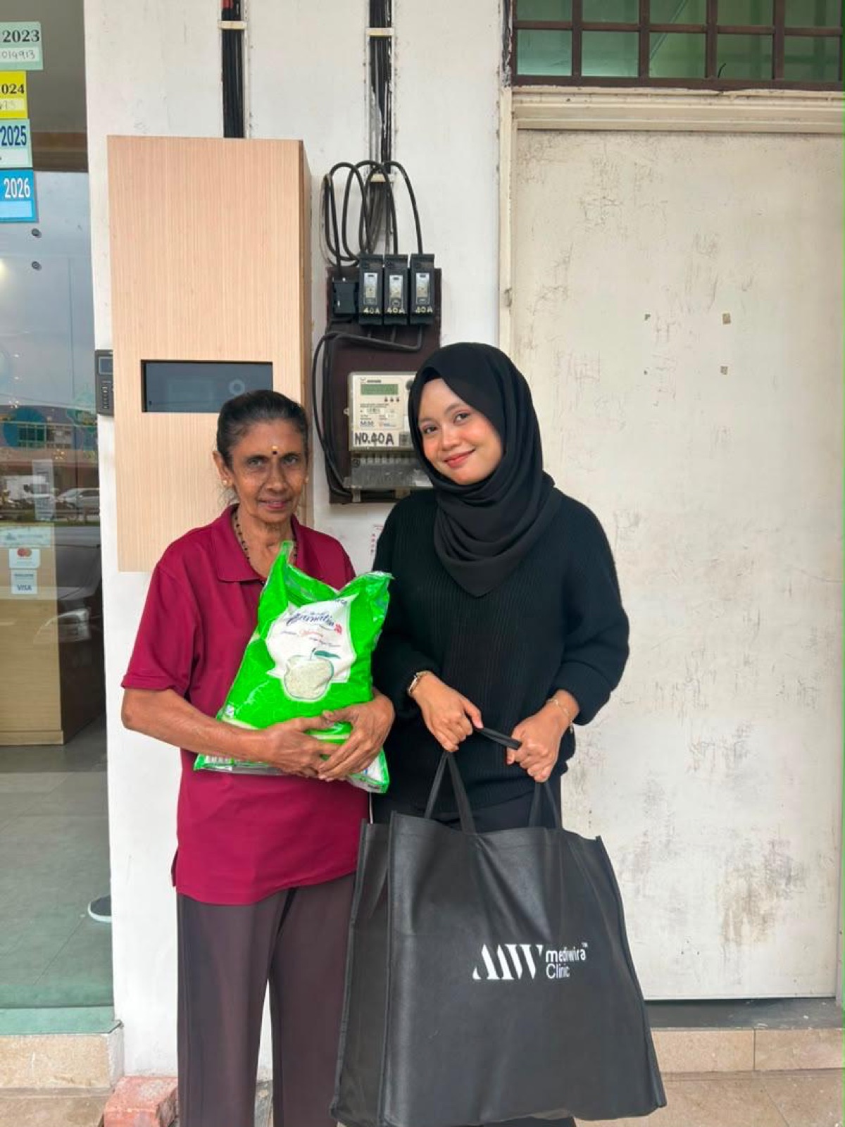 An elderly resident collecting rice and a Mediwira grocery bag