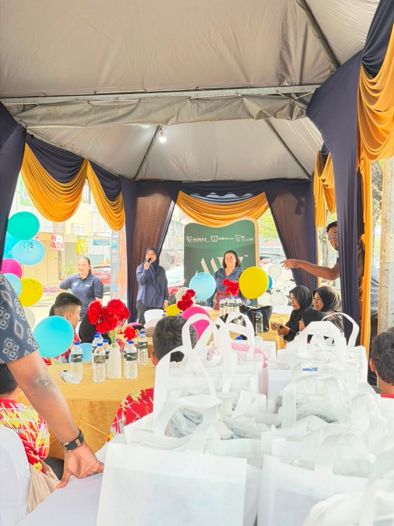 Inside the marquee, a host speaks into the microphone as goodie bags are stacked ready for guests