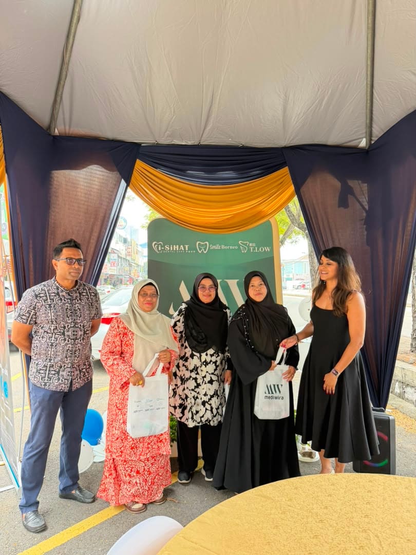 Another group of guests posing with their tote bags at the anniversary backdrop